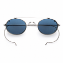 Oval sunglasses with dark blue lenses, a silver metal frame, and a double bridge design, shown on a plain white background.