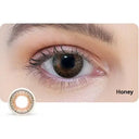 Close-up of an eye wearing a Honey colored contact lens with a close-up of the lens below.
