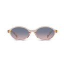 Oval sunglasses with a translucent light pink frame, gold metal hinges, and gradient gray-to-pink lenses, shown against a plain white background.