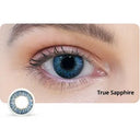 Close-up of an eye with a blue contact lens labeled 'True Sapphire' on a white background.