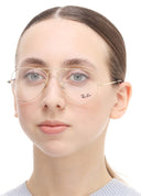 A girl wearing gold framed eyeglasses on a white background. 