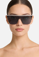 Front angle of a woman wearing sunglasses with dark lenses on a white background. 