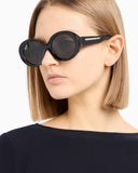 Side angle of a woman black sunglasses with dark tinted lenses n a white background. 