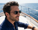 Side angle of a man wearing black oval sunglasses.